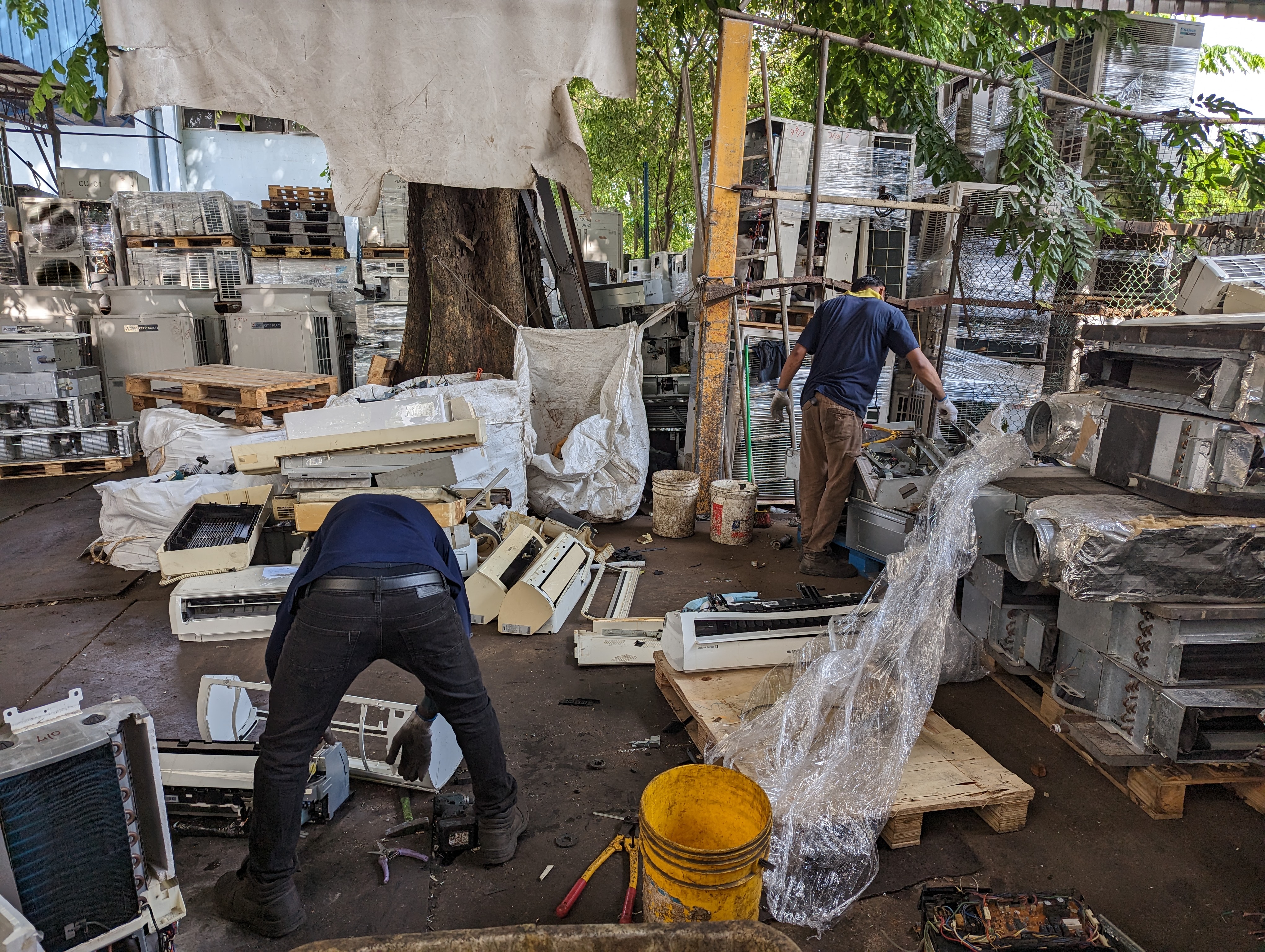 Employees scrap the indoor unit from a mini split air conditioning system. Photo: Tilden Chao, 2023.